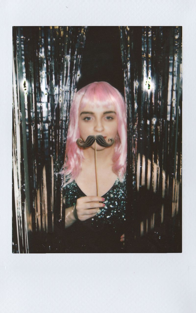Invitada posando con bigote de utilería